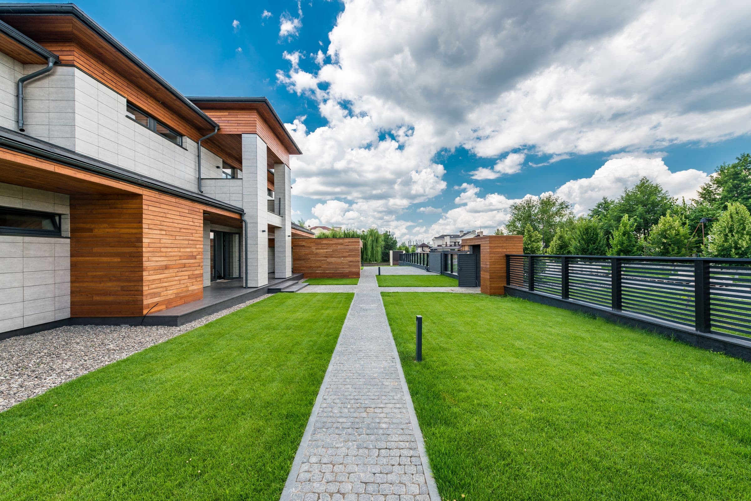 Gartenweg zu einem modernen Einfamilienhaus mit Holzfassade
