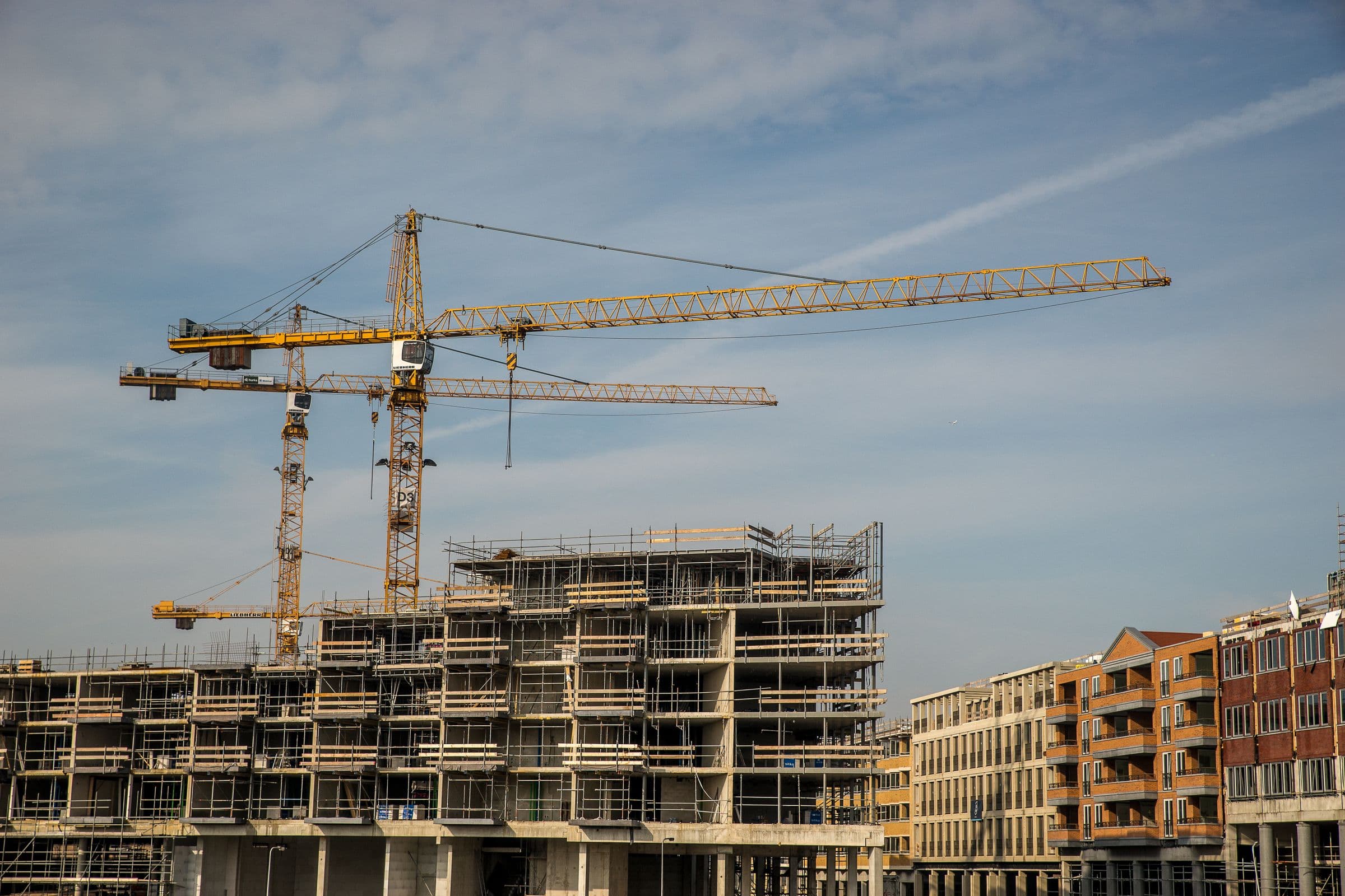 Kräne über einem Wohnungsbau im Rohbau