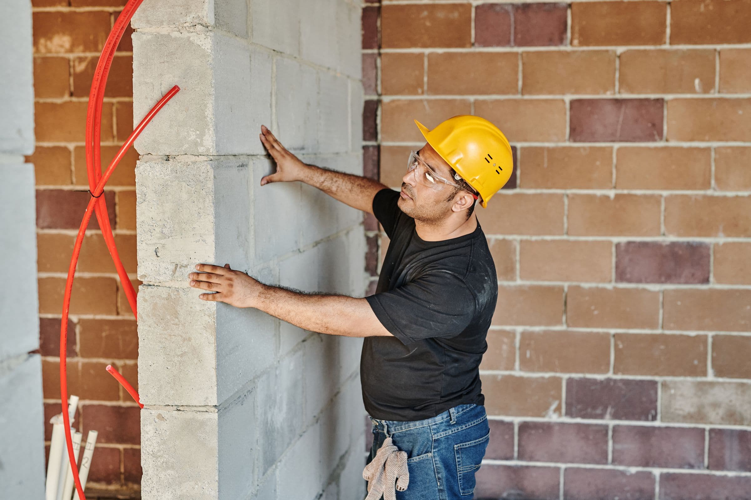 Maurer prüft eine Wand aus Kalksandstein