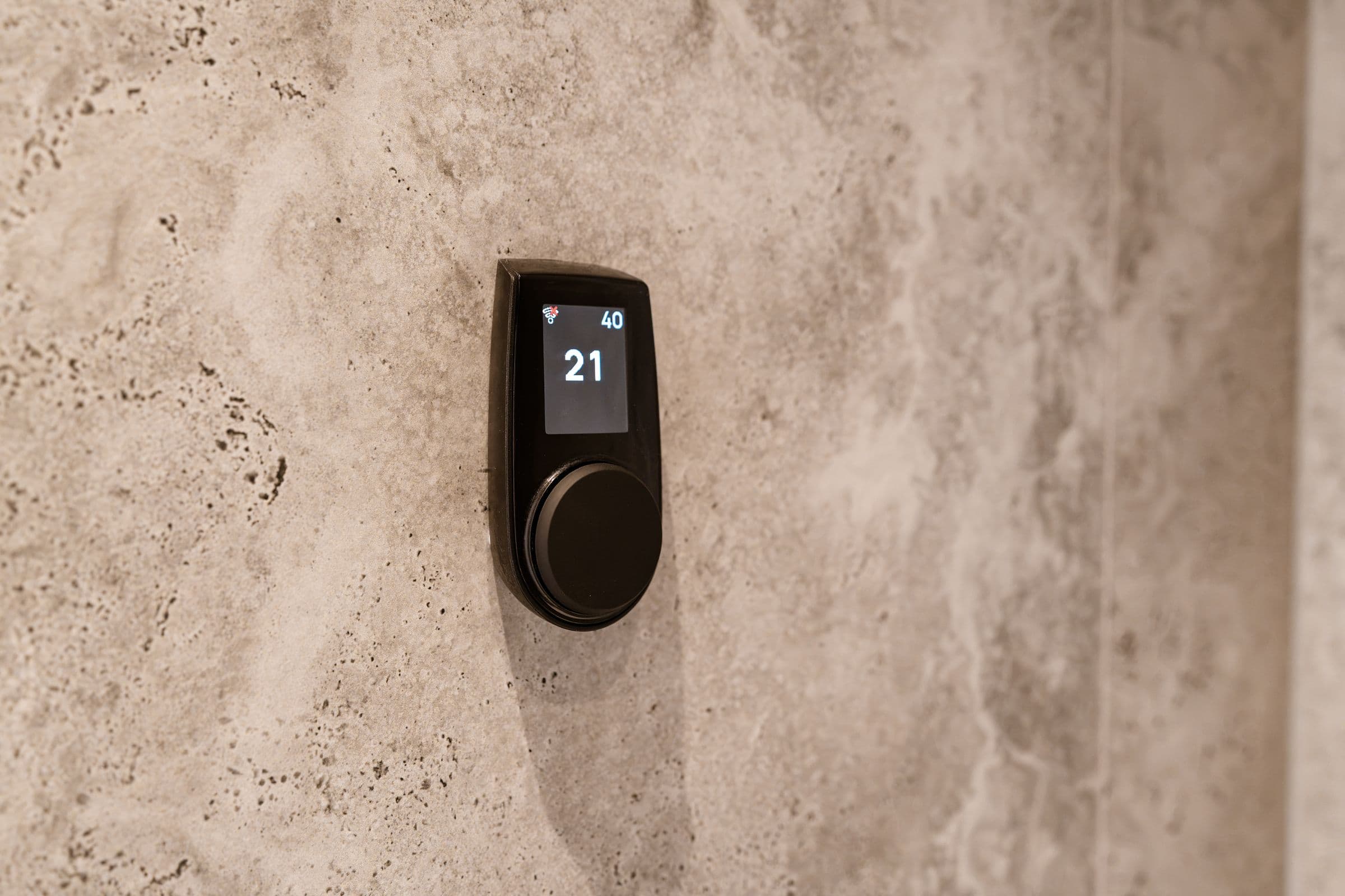 Raumthermostat an einer Natursteinwand